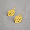 Detail of golden leaf earrings with hammered texture and irregular hollow design - Gold Matte Texture Hollow Leaf Shape Drop Earrings (55) / Gold