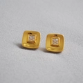 Macro detail of 18K gold plated square earrings with sparkling cubic zirconia stone center - Gold