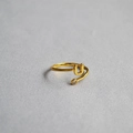 Detailed shot of golden adjustable ring featuring a letter U design and a small zircon stone - Alphabet Style U
