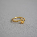Dettaglio ravvicinato dell'anello a forma di rosa e spine dorato con trame floreali fini - Aperto Regolabile / Anello Sottile Rosa Dorata Aperto