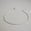 Macro shot of minimalist silver twist chain necklace on textured grey fabric background - Silver Length 38+6cm