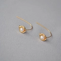 Detailansicht eleganter goldener Perlenohrringe mit gebogenem Haken und Knospenfassung - Gold
