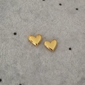 Macro shot of polished heart stud earrings in gold finish on grey velvet background - Gold