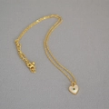 Detail of gold heart pendant with green zircon inlay and white mother-of-pearl finish - Gold Chain Green Heart Pendant