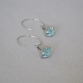 Dettaglio macro di orecchini a gabbia geometrica con zircone blu chiaro e argento - Argento & Zircone Blu Chiaro