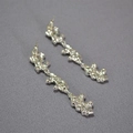 Detailed close-up of long liquid metal earrings with irregular lava texture in silver - Silver