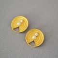Pendientes vintage de latón dorado con textura en espiral y perlas sobre superficie gris - Dorado