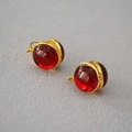 Dettaglio macro di orecchini vintage placcati oro con sfere di vetro rosso traslucido - Orecchini a Sfera / Rosso