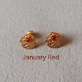 Close-up of golden textured stud earrings featuring a red January birthstone center - 1cm-January Red