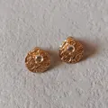 Macro shot of 925 silver needle stud earring with textured gold finish and white gemstone - 1cm-April White