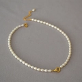 Elegante zoetwaterparelketting met dubbele gouden ringen op grijze achtergrond - Rijstparel Dubbele Ring Stijl (MYN0032-GD-MiZhu)