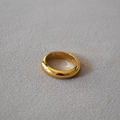 Detailansicht eines goldfarbenen Dome-Rings mit Hochglanzpolitur auf grauem Stoff - US 6 / Gold