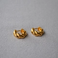 Macro detail of gold plated croissant twist hoop earrings with polished braided texture - Gold