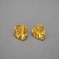 Macro-opname van gouden Monstera-oorbellen met fijne matte textuur en glanzende zirkoon - Goud