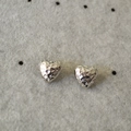Orecchini a cuore minimalisti in argento con trama martellata su sfondo grigio - Argento