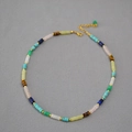 Detail of colorful stone beaded necklace with gold spacers and extension chain - Necklace