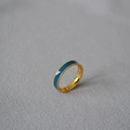 Dettaglio dell'anello in ottone placcato oro con smalto blu scuro su sfondo di tessuto - US 6 / Blu
