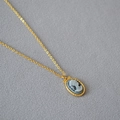 Macro shot of French vintage oval cameo pendant with twisted gold border on a fine chain - Chain With Moon Grey Girl Cameo