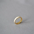 Macro di un anello in ottone placcato oro con smalto bianco su tessuto grigio testurizzato - US 8 / Bianco