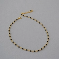 French style choker with black spinel beads and woven gold chain on a textured backdrop - Black