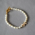 Elegantes Armband mit weißen Emaille-Schleifen und Süßwasserperlen sowie Goldverschluss - OT-Verschluss Schleifen-Stil / 17.5cm