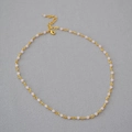 Detailed shot of the gold link chain featuring soft pink beads and lobster clasp - Pink