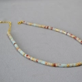 Dettaglio di collana artigianale con perline blu e accenti in metallo dorato - Zircone Blu Chiaro