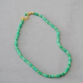 Detail view of green cylindrical stone beads with gold spacer beads and adjustable clasp - Green