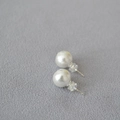 Dettaglio di orecchini a perla tonda con perni in argento 925 e chiusure in silicone - 10mm / Stile Fiore di Cotone