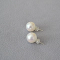 Close-up of elegant white round pearl earrings with 925 silver studs on grey fabric - 12mm / Artificial Mabe Style