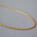 Macro view of a gold paperclip chain showing detailed rectangular links and brass texture - Short Style / Antique Gold