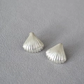 Macro shot of silver shell-shaped earrings with fan texture on grey fabric background - Antique Matte Silver