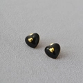 Elegante schwarze Emaille-Herzohrringe mit Goldrand auf grauem strukturiertem Stoff - Schwarz