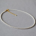 Nahaufnahme der weißen Perlenkette mit goldenem Karabinerverschluss und Verlängerungskette - 3mm Marke Künstliche Perle