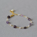 Detail of beaded gold chain necklace with purple stones and pearls on grey surface - Bracelet / Purple
