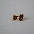 Dettaglio dell'anello dorato regolabile con pietre preziose rosse e viola - Viola + Rosso Vino