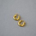 Minimalist gold chubby hoop earrings with matte finish on purple fabric background - Antique Gold