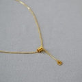 Dettaglio del ciondolo a cilindro placcato oro con texture scanalata su catena a maglia O - Oro