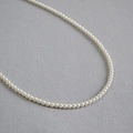 Dettaglio di eleganti perle avorio con elevata lucentezza su una collana girocollo - 3mm