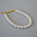 Détail d'un bracelet en perles blanches avec fermoir mousqueton doré et chaîne réglable - 6mm