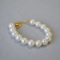 Gros plan détaillé de perles blanches sur un bracelet avec fermoir mousqueton doré - 10mm