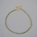 Detalle de collar de finas cuentas verdes con cierre de mosquetón dorado ajustable - verde oliva