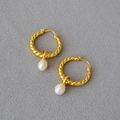 Orecchini a cerchio intrecciati dorati con perle d'acqua dolce su tessuto grigio - Stile Perla Torsione Oro