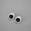 Vista macro detallada de aretes barrocos plateados con incrustación negra pulida - Plata Vintage (Estilo Ágata Negra)