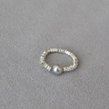 Detail van een minimalistische elastische ring met zilveren kralen en een grijze parel - Ruit Grijze Parel