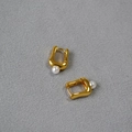 Elegantes pendientes dorados en forma de U con perlas redondas sobre fondo gris - Dorado