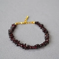 Macro view of irregular garnet stone beads with gold lobster clasp and adjustable chain - Garnet Style