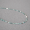 Makro-Detail von feinen hellblauen Aquamarin-Perlen und Silberperlen auf der Kette - Silber