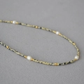 Collana retrò di perle con pietra dalmata, perle bianche e accenti dorati su tessuto grigio - Collana