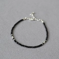 Dettaglio del bracciale con perline nere minimalista e chiusura a moschettone argento - Stile Spinello Nero Argento